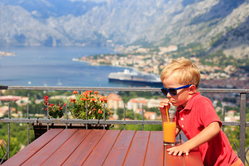 Fototapeta na wymiar little boy drinking juice in cafe
