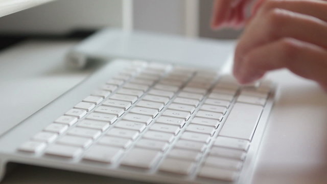 Woman hands typing on a keyboard in office setting