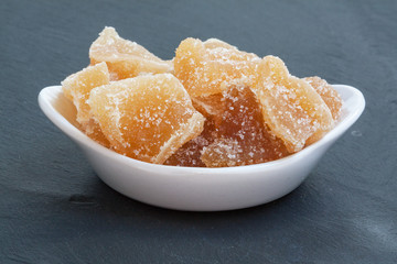 Gingembre confit dans un ramequin  sur fond d'ardoise