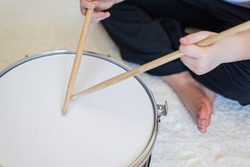 Boy teenager playing drums in  room