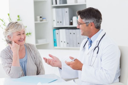 Doctor discussing with senior patient at table