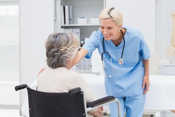 Obraz premium Nurse consoling patient sitting on wheelchair