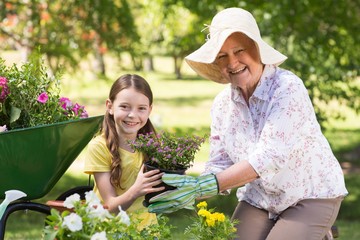 Happy grandmother with her granddaughter gardening