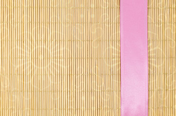 Wood, wicker background with pink ribbon