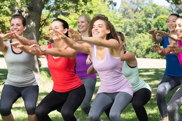 Fitness group squatting in park