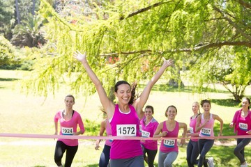 Smiling women running for breast cancer awareness