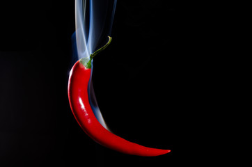 Smoking red hot chili pepper on black background - obrazy, fototapety, plakaty