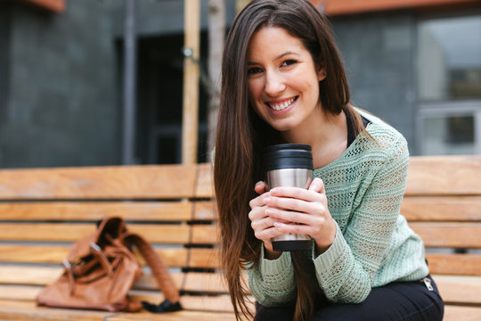Young beautiful woman drinking coffee in outdoors.