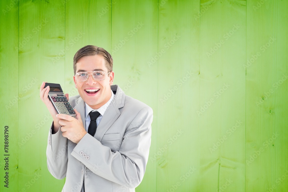 Poster Composite image of geeky smiling businessman holding calculator