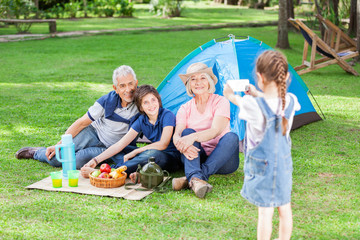 Girl Photographing Family At Campsite