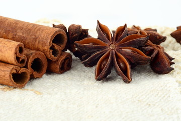 Closeup set of anise and cinnamon on white flax