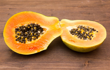 Papaya cut in half on wooden table
