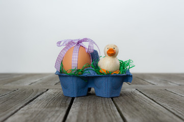 Frühstücksei  mit kleiner Ente in einem Eierkarton/Nest