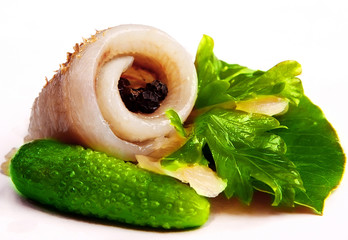Herring on a piece of lettuce.Two green cucumber.Peppers in peas