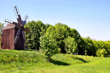 Oude windmolen op een heuvel in een veld. Tegen de achtergrond van