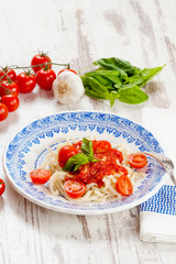 Healthy plate of Italian spaghetti topped with a tasty tomato an