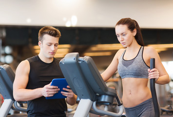 woman with trainer exercising on stepper in gym