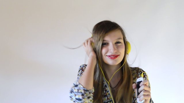 a teenage girl dance with headphone and phone in his hand