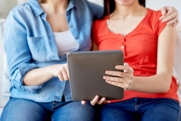 Naklejka premium close up of lesbian couple with tablet pc at home