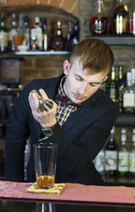 young man working as a bartender in a nightclub bar