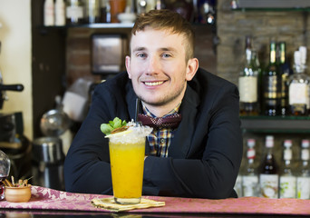 young man working as a bartender in a nightclub bar