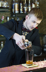 young man working as a bartender in a nightclub bar