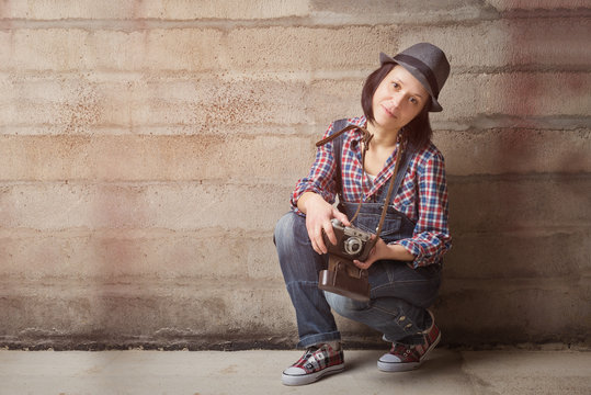 Indoor portrait of woman in a hipster style with vintage camera