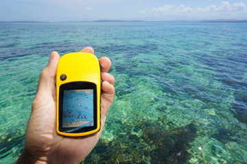 Hand holding a marine GPS navigator over the sea © dam
