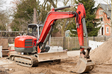 Strassenbau mit einem roten Kompaktbagger mit Raupenfahrwerk