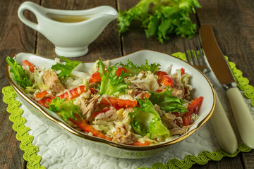 Salad with tuna and red pepper on a wooden table