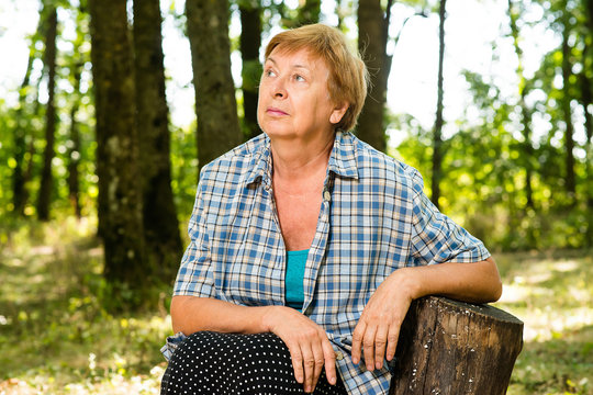 thoughtful grandmother in the forest