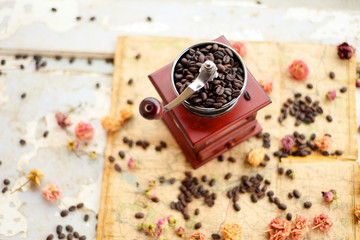 Coffee beans and dried roses scattered upon the old map