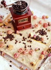 Coffee beans and dried roses scattered upon the old map