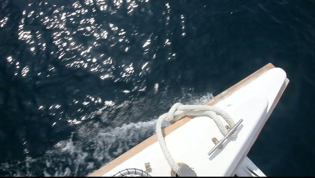 Segelboot, schnell auf dem Meer fahrend,  blaues Wasser. Spitze des Rumpfes eines Katamaran. Urlaubs-Symbol.