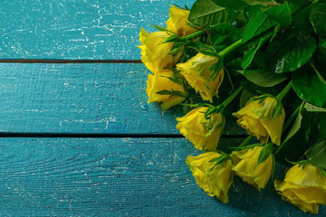 Fototapeta na wymiar Yellow roses on a blue wooden background