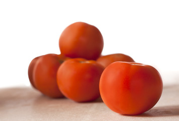 A heap of tomatoes on a wooden board