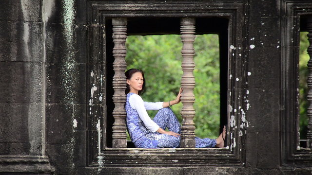Female Buddhist Meditating in Temple Window - Angkor Wat, Cambodia