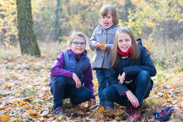 Happy Siblings - Three sisters in the autumnal forest smiling
