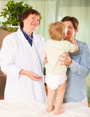 Fototapeta premium mature female pediatrician doctor examining toddler