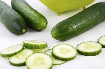 Slicing green cucumbers for salad food preparation