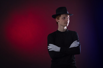 Portrait of a young man in a black hat and white gloves