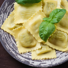 Close-up of italian ravioli with basil leaves, selective focus