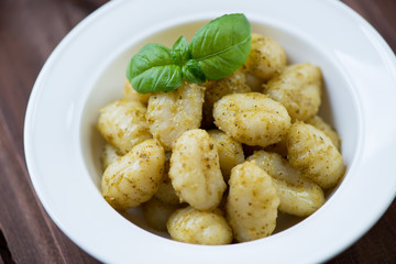 Boiled gnocchi with pesto sauce, close-up, selective focus