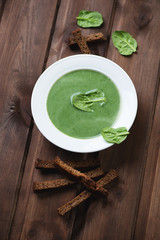 Freshly made spinach cream-soup with croutons, selective focus