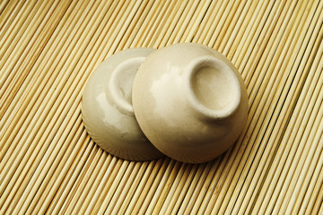 two ceramic bowl on bamboo matt