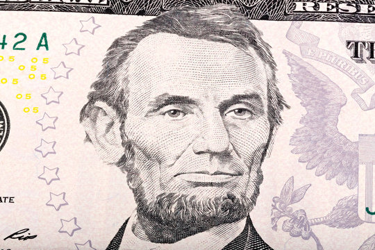 Stack of five U.S. Dollar. Close-up portrait of Abraham Lincoln.