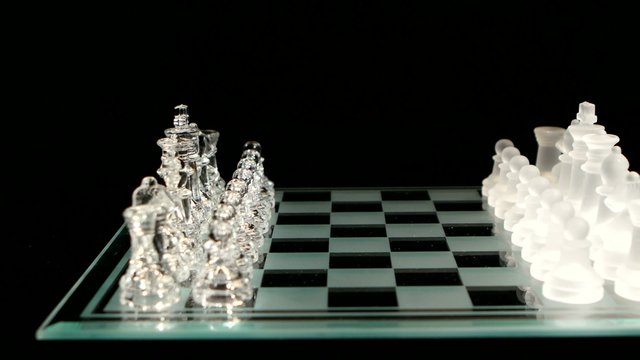 4K. Glass chess board with figures on black background