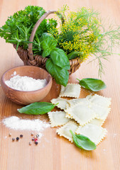 Homemade pasta ravioli with fresh basil, on wooden background