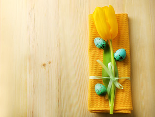 Yellow tulip, colorful eggs and napkin