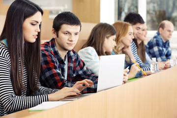 Group of students using gadgets in classroom